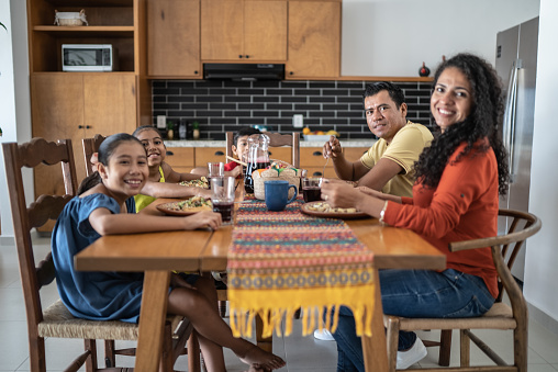 Portrait of Mexican family having lunch together in the dining room at home