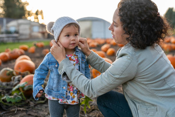 istock Ethnic thirty something mom and her toddler at a pumpkin patch 1415641389