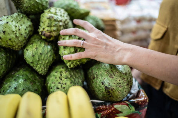 Selecting soursops at a local market