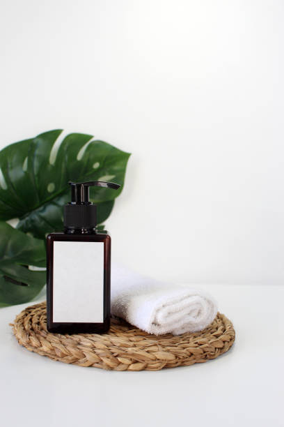 istock Blank plastic cosmetics container for cream or shampoo. Cosmetics bottle mockup with tropical leaves. Beauty product design, skincare and haircare concept. 1415641858