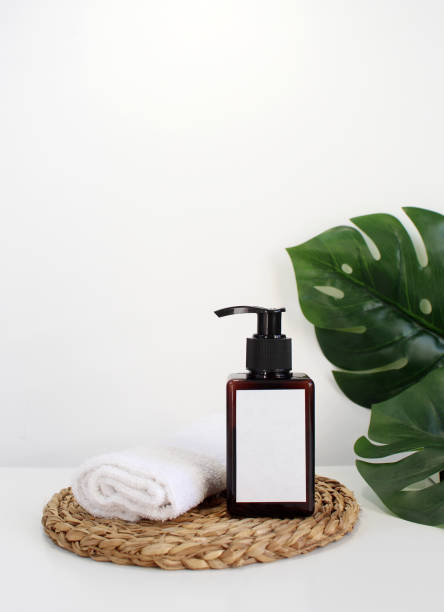 istock Blank plastic cosmetics container for cream or shampoo. Cosmetics bottle mockup with tropical leaves. Beauty product design, skincare and haircare concept. 1415641864