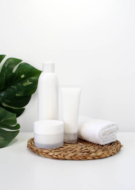 istock Blank plastic cosmetics container for cream or shampoo. Cosmetics bottle mockup with tropical leaves. Beauty product design, skincare and haircare concept. 1415641980