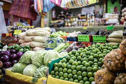 Young Woman Choosing Mango in Grocery Store. Concept of healthy food, bio, vegetarian, diet.