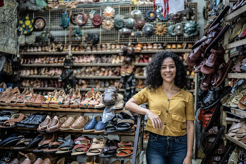 Portrait of mid adult woman in front of her shoe store