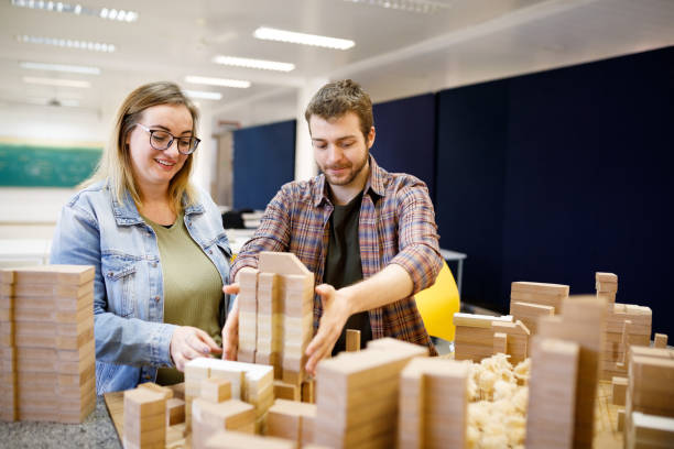 istock Students putting wooden blocks in a city model 1415644471