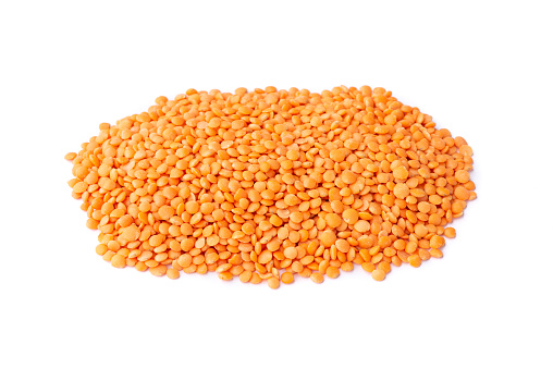 A pile of orange lentil isolated over white background.