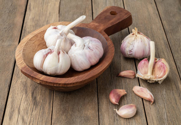 istock Garlic bulb and cloves on a plate over wooden table 1415644651