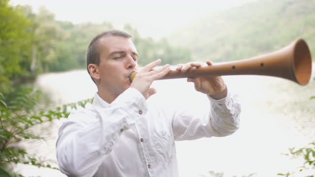 Male Folk Musician Closing Eyes While Playing Loud Zurna Instrument Through Forest
