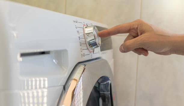 istock Hand stopping button of the washing machine 1415645957