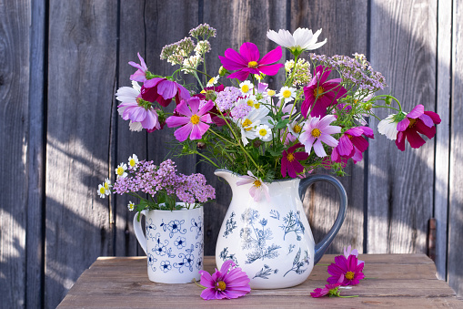 Bouquet of cosmos in vase outdoors