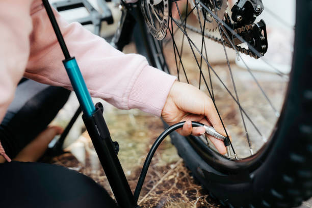 крупным планом женщина качает велосипедное колесо - bicycle bicycle pump inflating tire стоковые фото и изображения