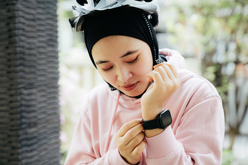 young muslim woman  tighten smartwatch on hands