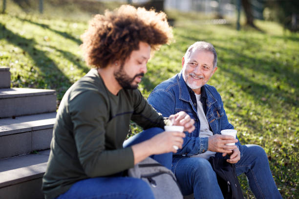 istock Students sitting on stairs steps and having a chat over coffee 1415647188