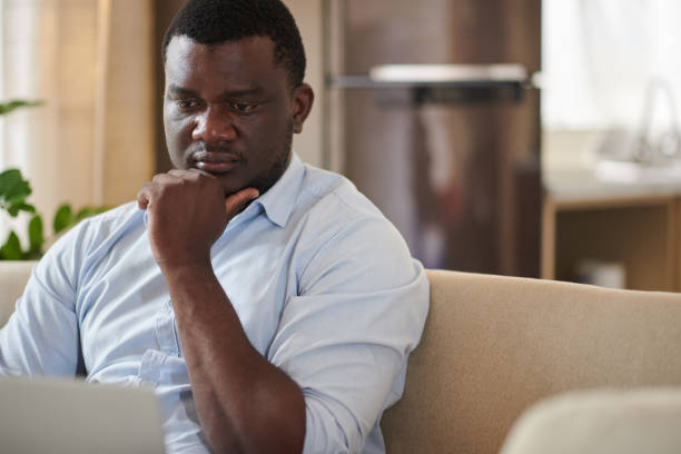 istock Pensive Businessman Reading Information on Website 1415647713