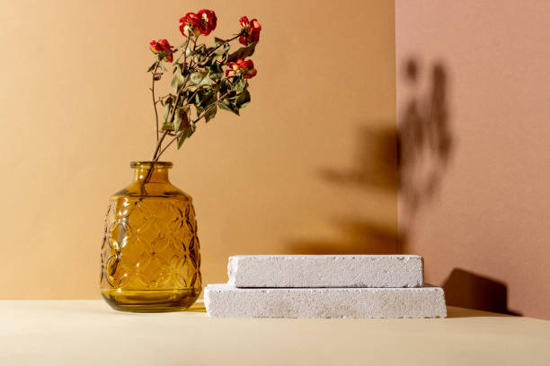 istock Background with geometric shapes made of concrete for cosmetic products. Rectangular podiums, glass vase with dried flowers and shadows on a beige background. Blank mockup for product 1415648939