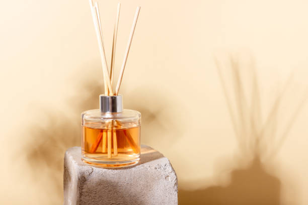 istock reed diffuser bottle on the podium. Incense sticks for the home with a floral scent with hard shadows. The concept of eco-friendly fragrance for the home 1415649001
