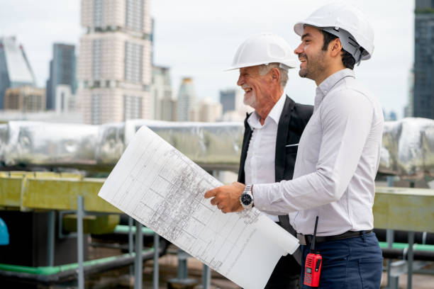 istock Two technician or professional engineers express happiness during work together on rooftop of construction site. 1415649396