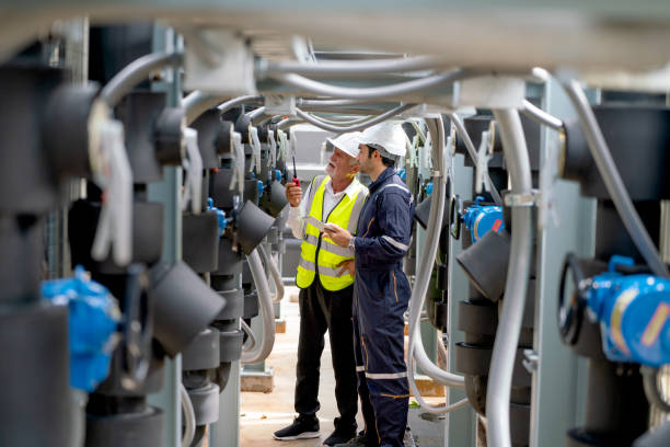 istock Two Caucasian engineer as young and senior worker look to leftside and discuss together and stay in channel of pipe network system of construction site 1415650080