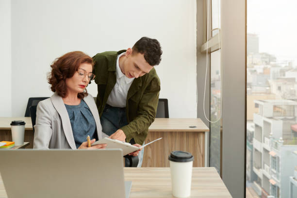 istock Business People Discussing Figures in Report 1415650256