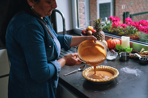 Preparing Pumpkin Pie for the Holidays in Domestic Kitchen