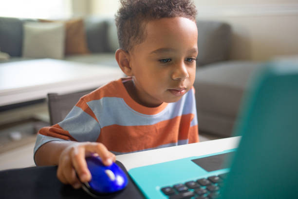 istock Close up leaning forwrd Mixed 3 year Old Boy learning on the Laptop Computer 1415650691