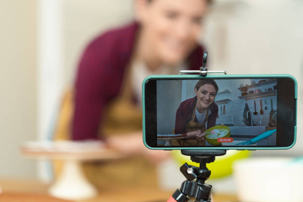 istock Young woman filming a baking tutorial with her smartphone 1415653296