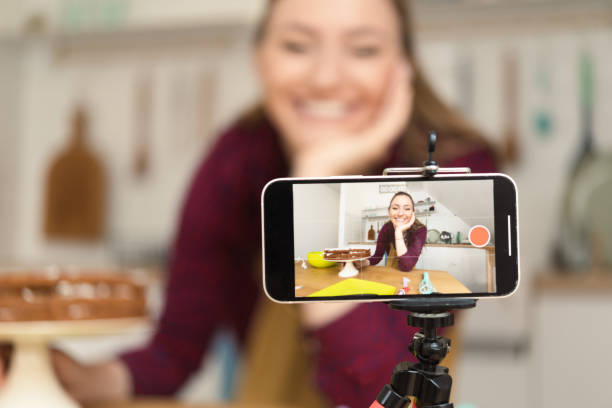 istock Young woman filming herself while making a cake 1415653350