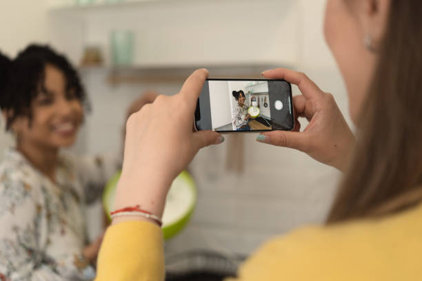 istock Girl filming her friend while she's making a cake 1415653355