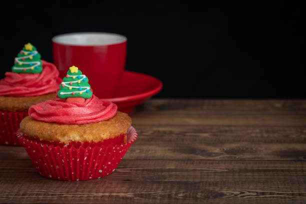 Cupcakes with Christmas tree Topper and Hot Drink on Dark Background with Copy Space