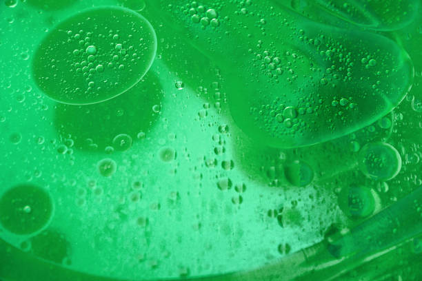 abstract green background formed by oil drops on water stock photo
