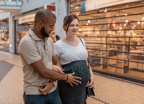 Mixed Race pregnant couple shopping for baby supplies for their new home