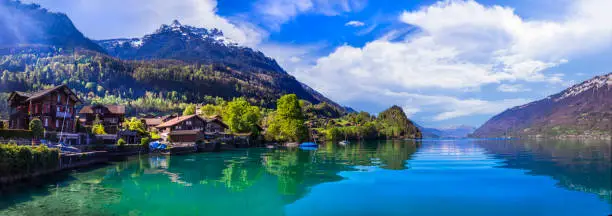 Stunning idylic nature scenery of mountain lake Brienz. Switzerland, Bern canton. Iseltwald village surrounded turquoise waters