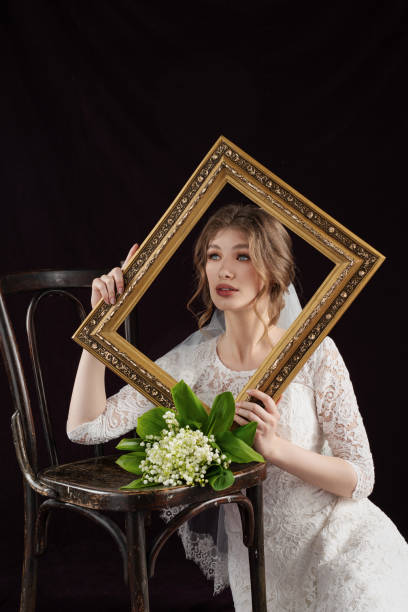 istock Bride in white deress taking a frame in front of their faces 1415662913