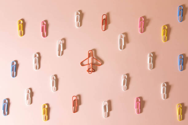 istock Colored paper clips on white background and airplane take off, forward movement concept. 1415663113
