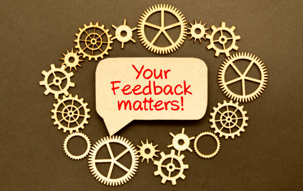 On a light background, text YOUR FEEDBACK MATTERS On a light background, a white alarm clock, pink, blue and white paper clips, a golden pen and a pink sticker with the text YOUR FEEDBACK MATTERS constructive feedback stock pictures, royalty-free photos & images