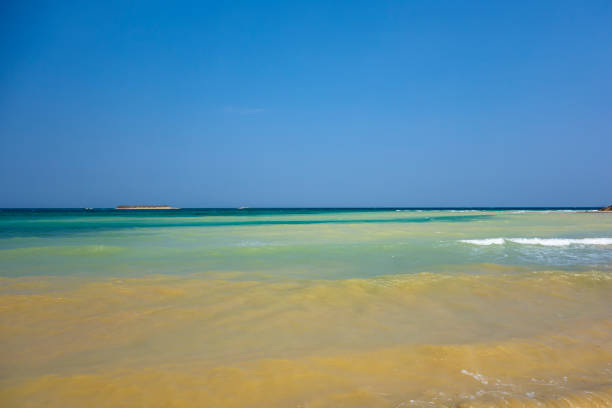 Soft wave of turquoise sea water on the sandy beach