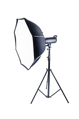 Flash on a tripod with a nozzle on a white isolated background.