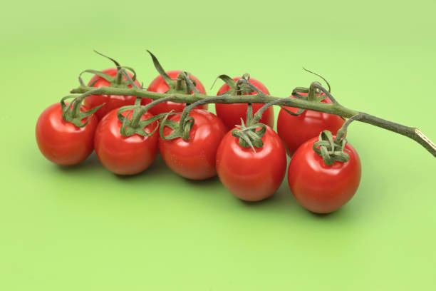 istock Fresh cherry tomatoes on green professional chopping board 1415669452