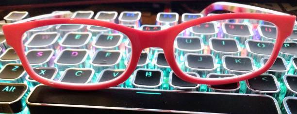 istock Neon keyboard and red eyeglasses 1415669479