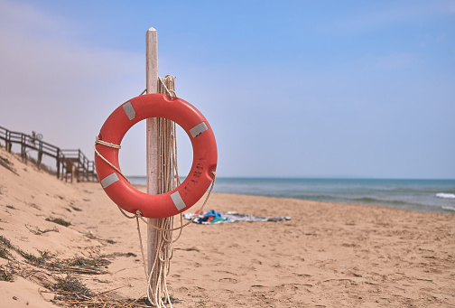 detail of a float or lifebuoy on a post on a beach