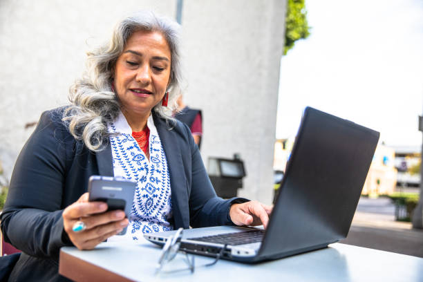 istock Latina Businesswoman Using Tablet at Cafe 1415672163