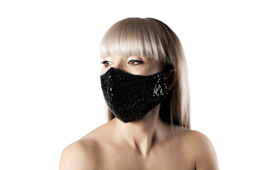 Beautiful brunette girl with blond hair fringe bangs wearing black fashionable protective face mask.