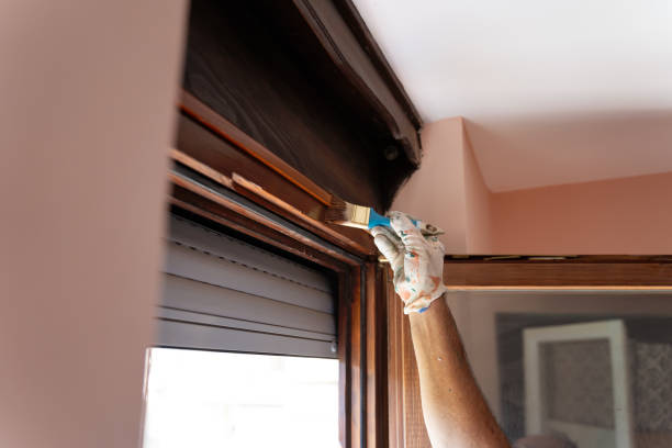 istock Senior man applying protective varnish on a wooden window 1415677247