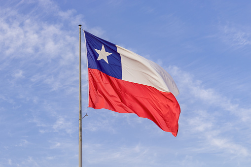 Bandera chilena izada en buen estado con cielo azul de fondo, concepto: fiestas nacionales chilenas photo