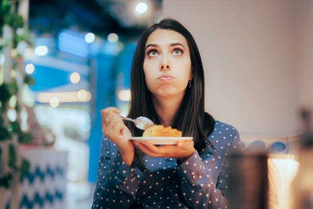 istock Doubtful Woman Thinking about Eating a Pie Dessert 1415679856