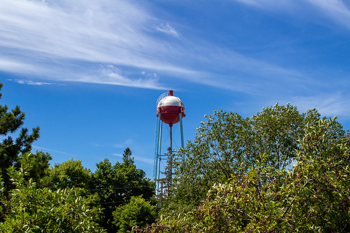 Pequot Lakes, Minnesota, USA - August 11, 2022: Daytime view of the round fishing bobber shaped city water tower, in the popular lakes region around the town of Pequot Lakes in northern Minnesota.