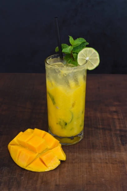 istock Mango mojito in highball glass with sliced mango on wooden table 1415700076