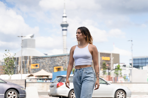 Confident Maori woman looking away at road in city.