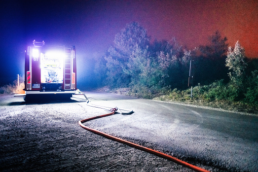Fire truck on country road in fire fighting operation at night