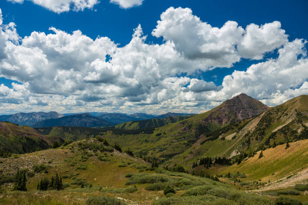 istock Alpine tundra hills and mountain peaks with big clouds 1415707991